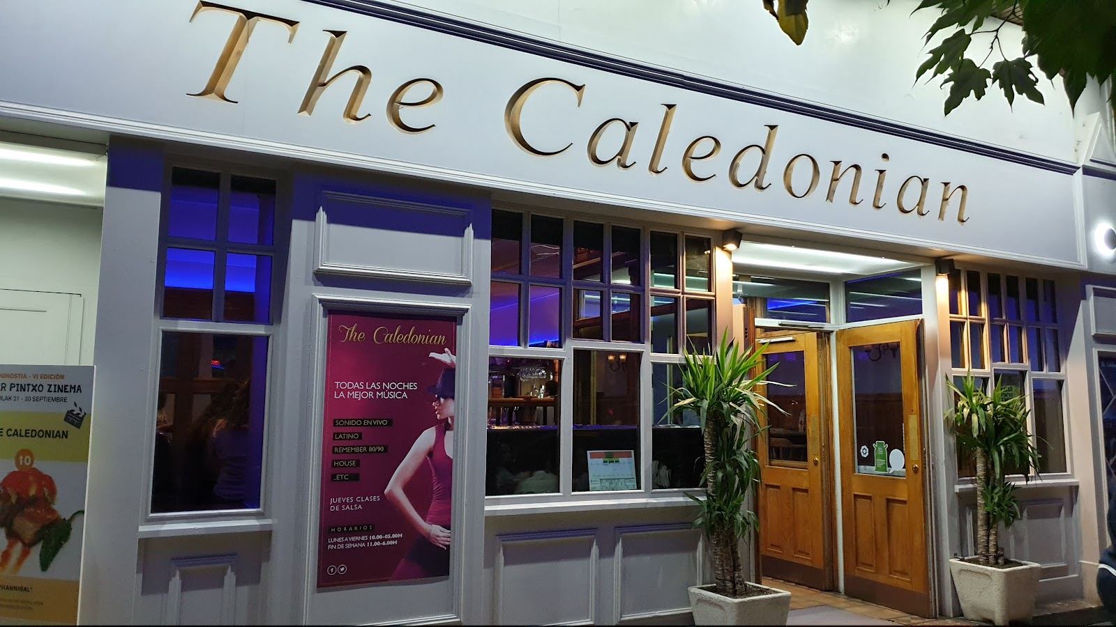 Fachada de The Caledonian de noche, con su rótulo dorado